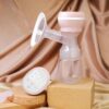 Extractor De Leche Materna Eléctrico Enzo Rosa Úpale producto y vaso